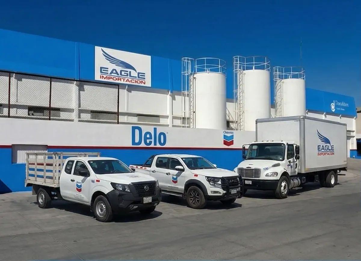 Camionetas y camión de reparto de Eagle Importación estacionados frente al centro de distribución